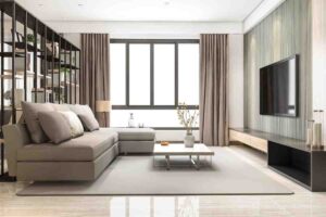 Modern living room featuring a gray sectional sofa, minimalist decor, large windows, and a sleek TV unit with natural light.