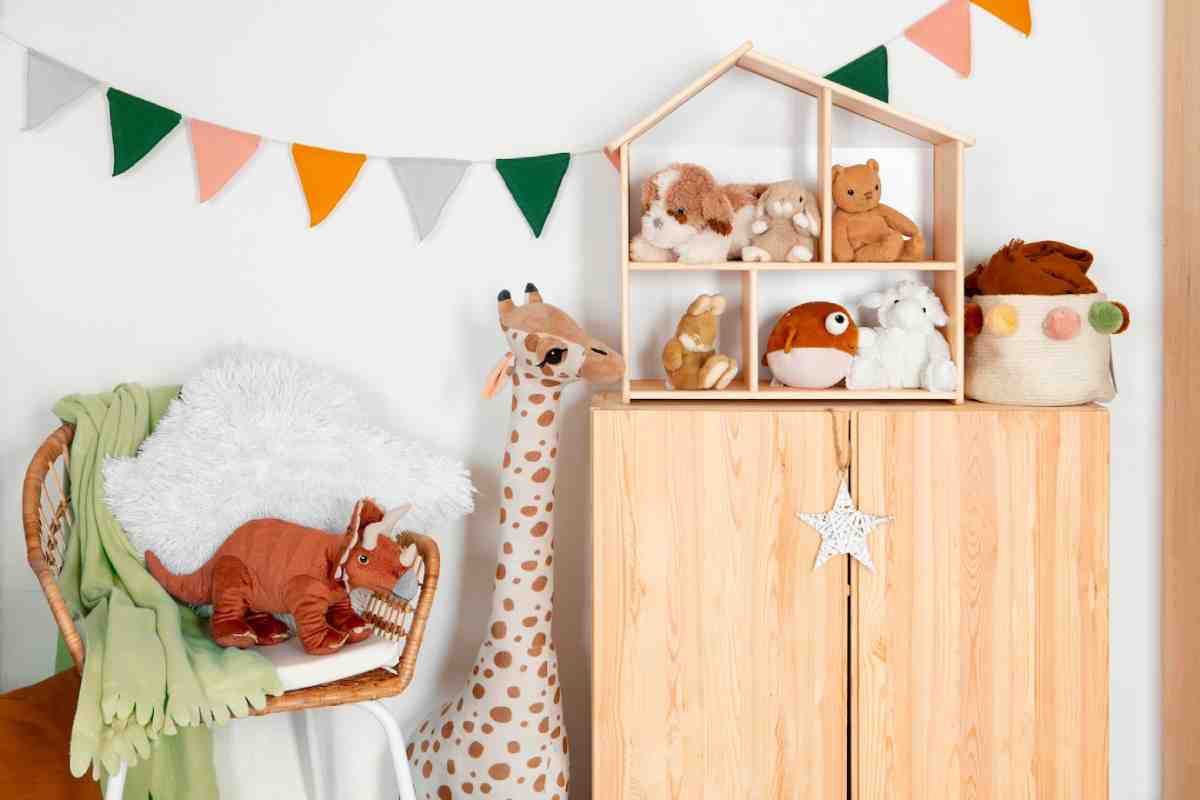 Colorful children's room with a wooden cabinet, plush toys on display, a cozy chair, and decorative bunting.